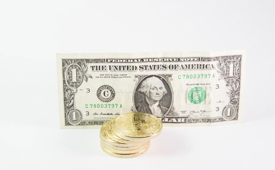 Bitcoins stacked with a dollar bill on a white background