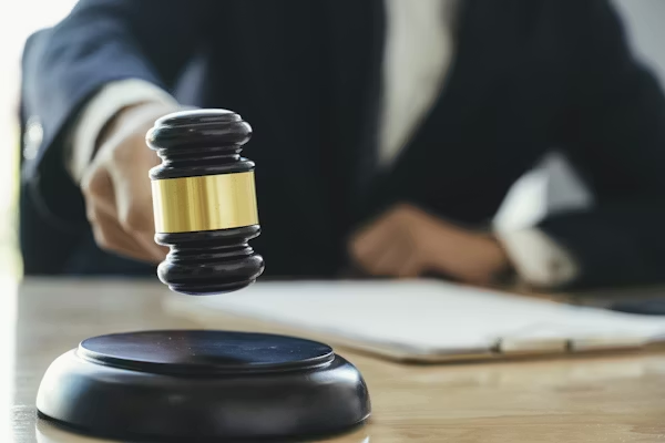 A hand holding up a gavel