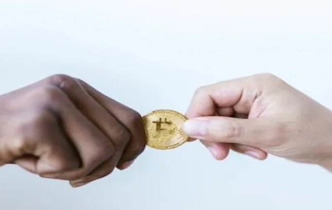 Close-Up Shot of Two People Holding a Gold Coin