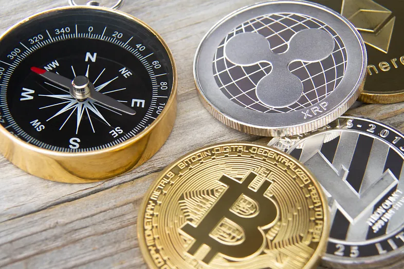 A compass next to cryptocurrencies 