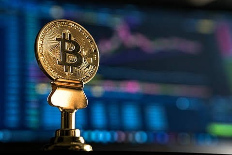 Brown, gold, coloured bitcoin on a brown table stand