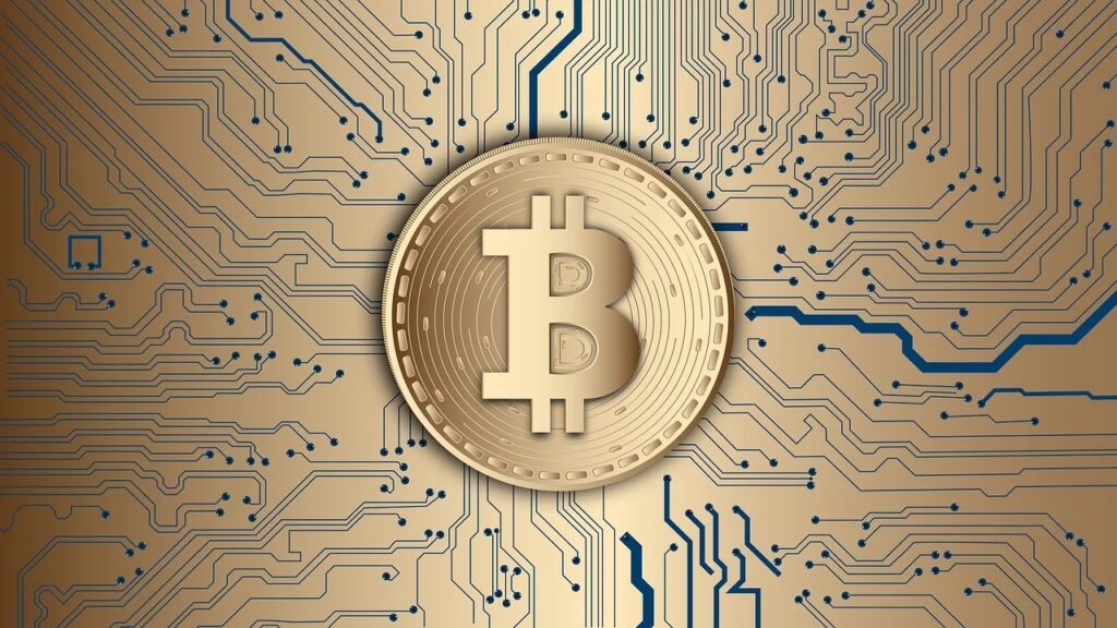 Bitcoin gold coin with the center having the letter "B" on top of a circuit board background.
