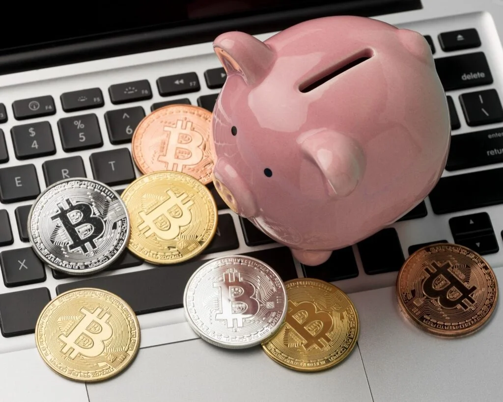 Cryptocurrencies with piggybank on laptop.