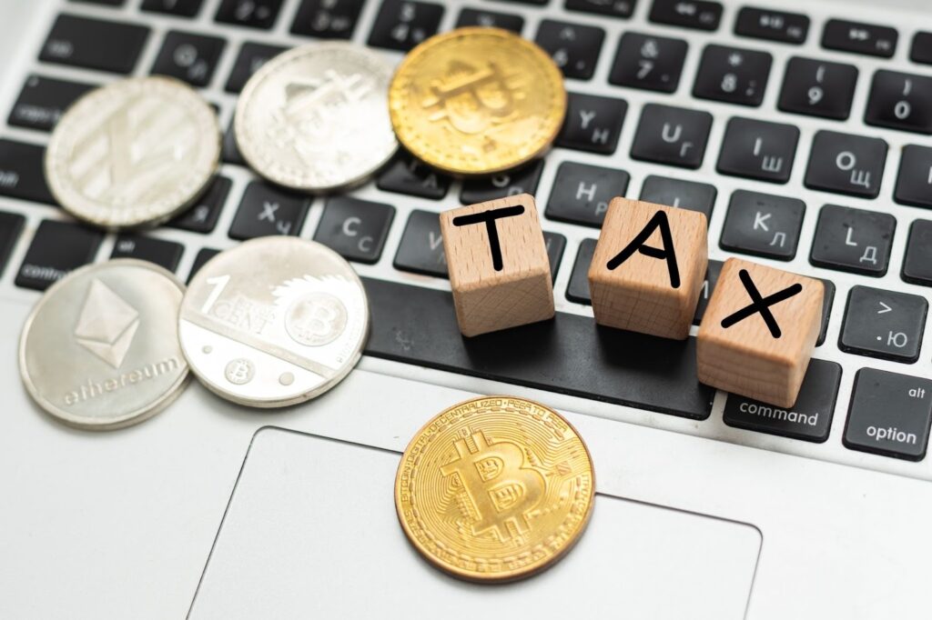 Bitcoin and next to wooden with TAX letters.