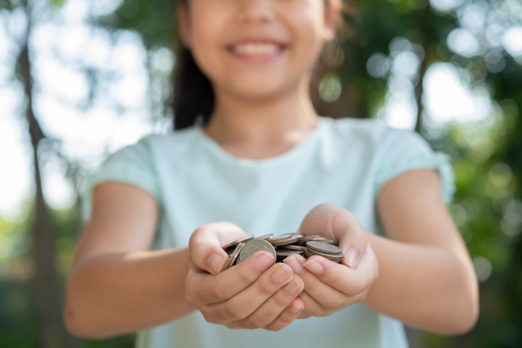 Cute little girl playing with a stack of coins.