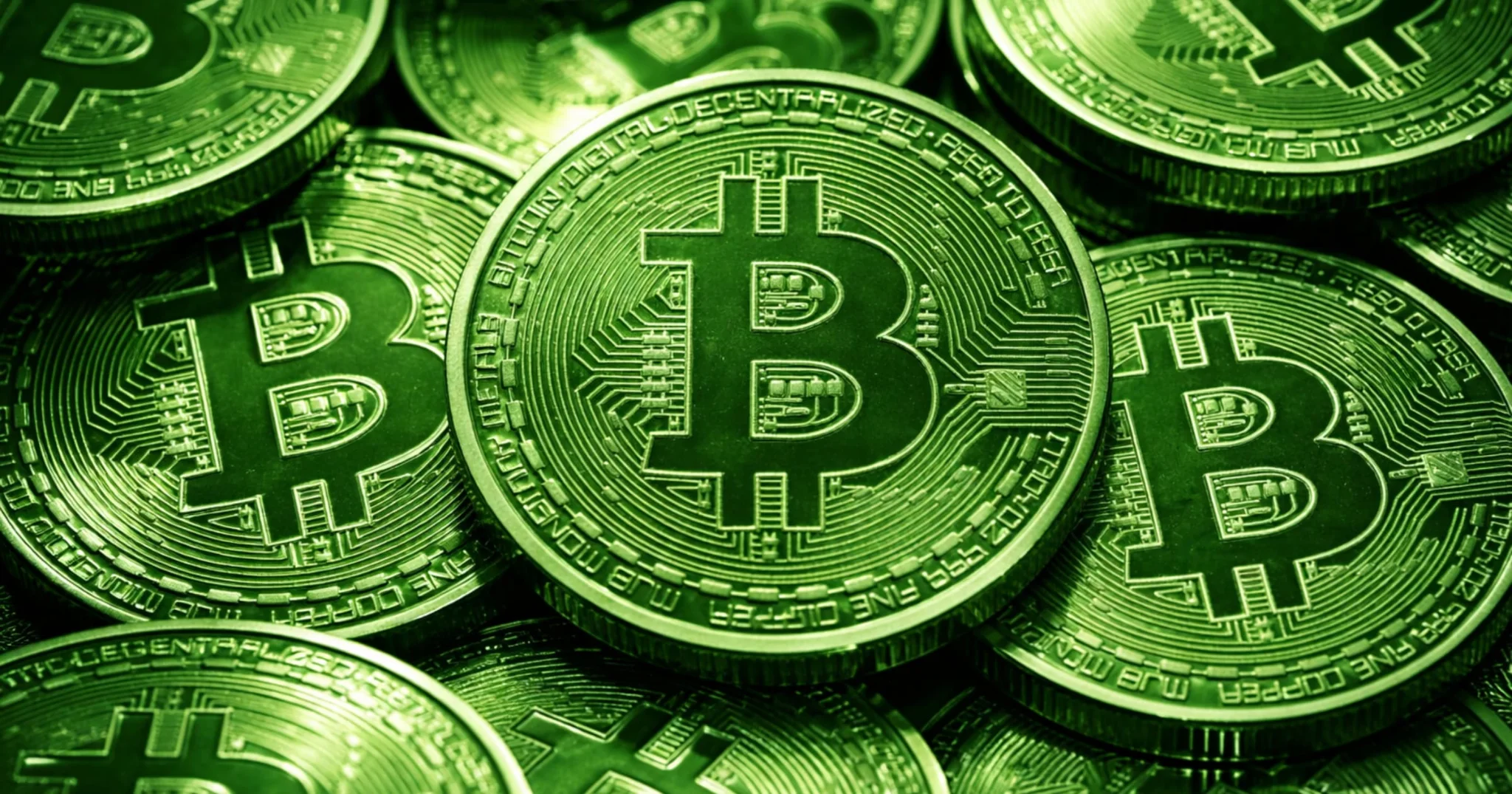 stacked of Bitcoin coins with a green tint, showing the BTC logo and circuit design.